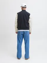 Campera bomber de manga larga y cuello estilo baseball, color azul marino con mangas beige. Tiene cierre de botones, puños acanalados y bolsillos delanteros. Confeccionada en tejido plano con detalle de logo.