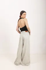 Pantalón de lino blanco de tiro alto, corte wide leg y bolsillos delanteros tipo ojal.