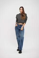 Buzo corto de tejido de punto con diseño a rayas horizontales blancas y negras, cuello redondo y mangas largas.