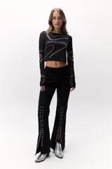 Remera negra de mangas largas transparentes, con apliques de brillos formando ondulaciones.