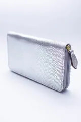 Billetera rectangular con cierre perimetral, confeccionada en cuero con textura de reptil. Cuenta con múltiples compartimentos internos para tarjetas, documentos y billetes, además de un bolsillo interior con cierre para monedas.