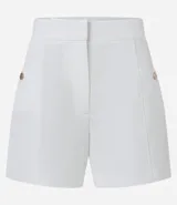 Short sastre de cintura alta con estructura definida, bolsillos laterales decorados con tachuelas metalizadas y recortes delanteros con costura aparente.