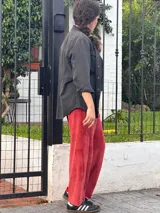 Pantalon de corte barrel en plush de algodon color bordó, con tiro medio, bolsillos frontales y traseros, y faja ancha en la cintura.