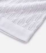 Polo de manga corta color blanco, con cuello en V y textura de rombos abiertos. Confeccionado en algodón.