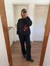 Buzo negro de corte holgado con estampa de una langosta roja en el frente.