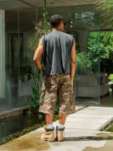 Bermuda cargo de gabardina con lavado, estampado camuflado en tonos marrones y verdes. Presenta bolsillos cargo a los costados y terminación deshilachada en el ruedo.