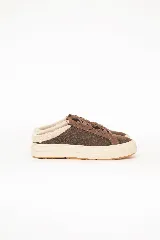 Zueco estilo sneaker marrón con cordones, suela plataforma de goma blanca y ribete interno de corderito sintético.