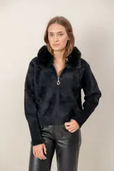 Campera de textura peluda en color negro, con cuello alto de piel sintética, cierre frontal completo y puños tejidos acanalados.