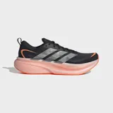 Championes de running Adidas Supernova Glide, color negro con detalles en plateado y suela de espuma en tono naranja traslúcido. Presentan un diseño aerodinámico con empeine textil ligero y sistema de cordones.