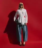 Pantalón barrel de jeans de tiro medio, con piernas amplias y afuniladas en el ruedo. Posee bolsillos funcionales, trabillas y cierre delantero con botón y cremallera.