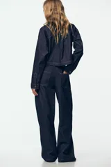 Pantalón de jean de tiro alto con corte de pierna ancha, cintura elástica con cordón ajustable y bolsillos laterales.