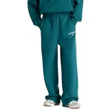 Pantalón deportivo New Balance de corte holgado, confeccionado en felpa cepillada color verde. Presenta cintura elástica con cordón ajustable, bolsillos laterales y logo de la marca estampado en la pierna izquierda.