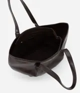 Cartera tipo shopper grande de la marca Satinato, confeccionada en poliuretano con textura tipo crocco. Presenta un diseño en forma de trapecio invertido con asas dobles estructuradas para llevar al hombro o en la mano, cierre principal por cremallera y detalles en metal color dorado claro.