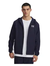 Campera cortaviento Under Armour modelo Rivl Wvn, color azul marino con detalles en blanco. Presenta cierre frontal completo, capucha ajustable con cordones, bolsillos laterales con cierre y puños elásticos.