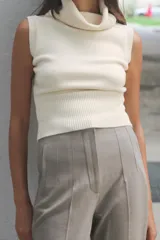 Pantalón tobillero gris oscuro de tiro alto con costuras marcadas en delantero y espalda, bolsillos delanteros de vivo y cierre frontal con cremallera, botón interior y gancho metálico.