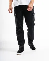 Pantalón cargo negro de corte slim, confeccionado principalmente en algodón con un pequeño porcentaje de spandex para elasticidad. Presenta múltiples bolsillos utilitarios con tapa y remaches de refuerzo.