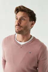 Sweater de punto color rosa con cuello en V y logo bordado en el pecho.