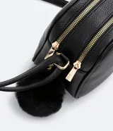 Bolso pequeño femenino de PU color blanco, con correa para cruzar, cierre de cremallera, divisorias internas y pompón decorativo.