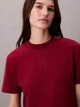 Remera Calvin Klein de manga corta y corte regular, color bordó, confeccionada en algodón interlock con cuello redondo y emblema geométrico bordado en el pecho.