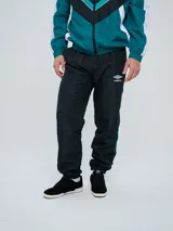 Pantalón de jogging Umbro color azul marino, de corte recto, con cintura elástica y líneas blancas decorativas a los laterales. Presenta el logo de la marca bordado en blanco en la pierna izquierda.