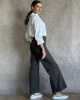 Pantalón de jean estilo wide leg con costuras verticales frontales, tiro alto y bolsillos laterales.