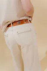 Pantalón de jean de tiro medio y pierna ancha, confeccionado en denim 100% algodón. Diseño con 5 bolsillos y pespuntes a contratono.