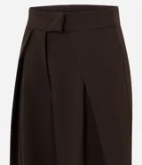 Pantalón de sastrería en crepé color marrón, de modelaje barrel y tiro alto con cintura estructurada. Presenta pinzas frontales profundas, bolsillos embutidos y caída amplia de corte recto.