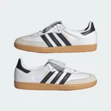 Championes Adidas Samba LT de diseño retro, confeccionados en cuero de primera calidad con puntera de nobuk. Presentan las icónicas tres bandas laterales en negro, suela de goma color caramelo y una lengüeta extragrande inspirada en las botas de fútbol clásicas.