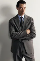 Blazer regular fit de Zara, confeccionada en tejido gris con mezcla de lana, con solapas de muesca, cierre de botonadura frontal y bolsillos con solapa en la cadera.