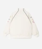 Campera bomber oversized de microfibra color beige, con cierre frontal por cremallera, cuello alto y bolsillos delanteros. Presenta estampado frontal con la inscripción "PARIS 1985" en color negro, además de detalles estampados en las mangas. Cuenta con puños y ruedo elásticos.
