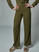 Mono enterito verde militar de lino, con solapas en el cuello, mangas largas y cinturón con hebilla forrada del mismo tono.