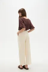 Pantalon de jean estilo barrel, color natural, de tiro medio con bolsillos laterales y cierre frontal.