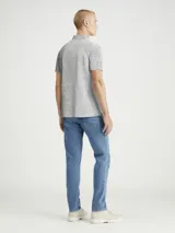 Chomba gris jaspeado de piqué de algodón peinado, con cuello clásico y tapeta de dos botones. Tiene mangas cortas, dobladillo con aberturas laterales y logo de Calvin Klein en la manga.