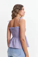 Blusa de algodón a cuadros color celeste y rosado, con escote recto, breteles finos y fruncido en el cuerpo.