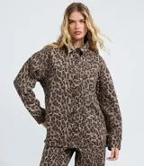 Camisa de corte oversized confeccionada en denim de algodón, con estampado animal print. Presenta cuello camisero, cierre frontal abotonado, manga larga y bolsillo en el pecho.
