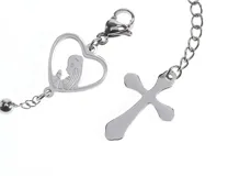 Pulsera tipo rosario de acero con baño de plata, compuesta por pequeñas cuentas esféricas, un dije en forma de corazón con la figura de la virgen niña en su interior y un colgante con una cruz.