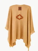 Ruana de tejido de punto en color beige con diseño de rayas diagonales sutiles. Presenta un aplique central con forma de cruz escalonada en color marrón y bordes con flecos.