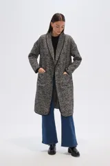 Tapado largo de poliéster con estampado de espiga en tonos grises y negros, con solapas y bolsillos laterales.