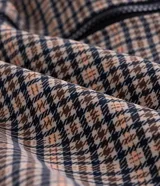 Campera masculina de corte regular con estampado a cuadros, cierre frontal con cremallera y capucha fija con borde de pelo sintético. Cuenta con bolsillos frontales con solapa y cierre de botón a presión.