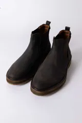 Bota tipo Chelsea de cuero color marrón oscuro, con paneles laterales elásticos y suela de goma con efecto madera.