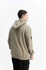 Canguro con capucha y cordones ajustables, de corte holgado y bolsillo frontal tipo canguro. Presenta un pequeño logo estampado en el pecho.