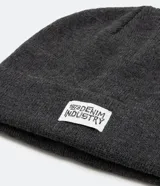 Gorro de tejido de punto color lila, estilo beanie con borde doblado y etiqueta frontal.