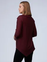 Blusa de tejido piqué con estampado geométrico en tonos negro y bordó. Presenta cuello volcado, mangas tres cuartos y un diseño de ruedo asimétrico.
