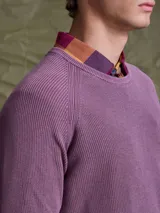 Sweater de punto en color azul marino, con cuello redondo y mangas raglán. Presenta un tejido acanalado fino y puños elásticos.