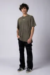 Remera de manga corta, corte holgado, color verde oliva con efecto acid wash. Presenta un pequeño estampado blanco en el pecho con el texto "ASTRAL ENERGY" y un símbolo gráfico debajo.