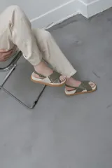 Sandalias bajas color verde oliva, con dos tiras anchas cruzadas sobre el empeine y tira trasera con hebilla.