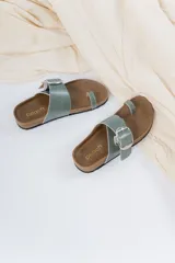 Sandalias planas de cuero negro con diseño cruzado, hebilla metálica regulable y tira al dedo.