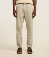 Pantalón masculino relaxed fit confeccionado en oxford de algodón, color beige, con trabillas en la cintura y cordón ajustable con lazo. Cuenta con bolsillos delanteros y traseros.