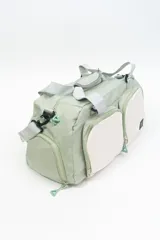 Bolso deportivo color rosa con detalles en beige y gris. Tiene doble asa de mano y correa de hombro ajustable. Cuenta con dos bolsillos frontales con cierre y logo de la marca en la esquina inferior derecha.