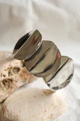 Brazalete rígido plateado con tres discos irregulares de alpaca.